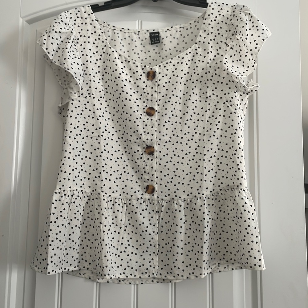 White blouse with black hearts & brown buttons up front.
